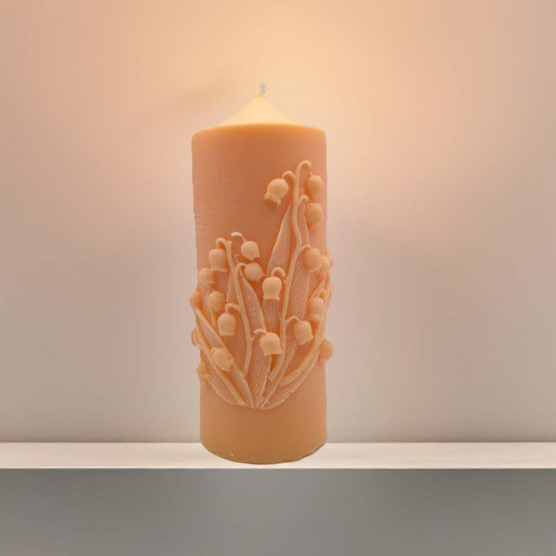 Handgegossene Kerze mit Maiglöckchen-Motiv aus Rapswachs auf weißem Hintergrund