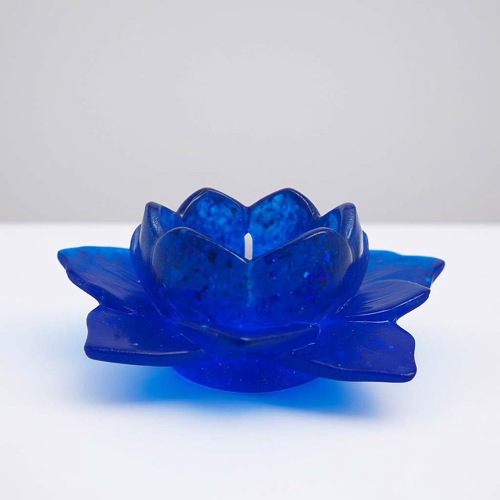 Handgefertigter Kerzenhalter in Lotosblumenform aus blauem Epoxidharz mit Glitzereffekten – auf weißem Hintergrund fotografiert.