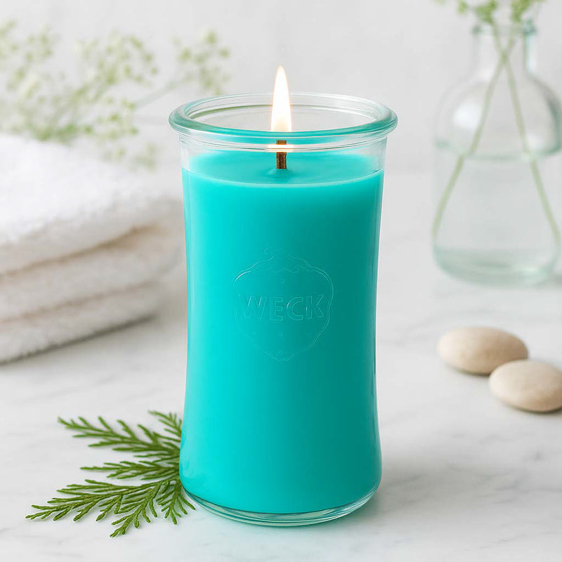 Leuchtend türkisfarbene Duftkerze Anti-Tabak im WECK-Glas auf hellem Tisch, mit frischer Dekoration in Weiß und Grün – klare, reine Atmosphäre.