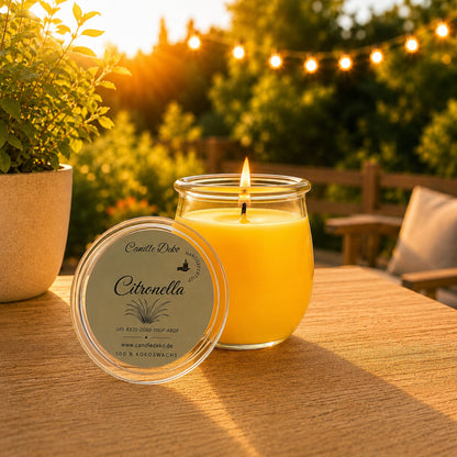 Citronella Duftkerze aus Kokoswachs im WECK-glas auf Holztisch vor leuchtender Lichterkette bei Sonnenuntergang.