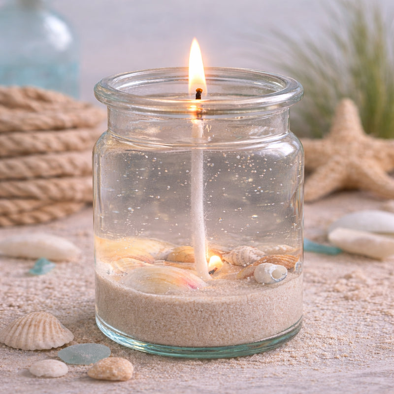 Handgegossene Gelkerze mit echten Muscheln im Glas – maritimes Deko-Highlight mit Sand, Küstenflair und sanftem Kerzenschein.