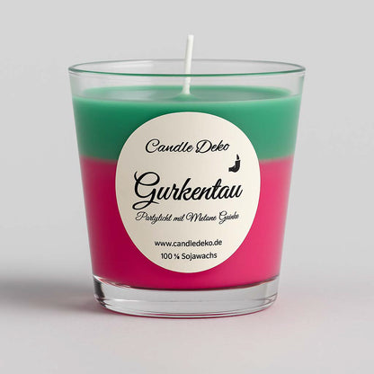 Zweifarbige Duftkerze im Glas mit oberer grüner und unterer pinker Farbschicht. Etikett mit der Aufschrift "Gurkentau – Partylicht mit Melone-Gurke".