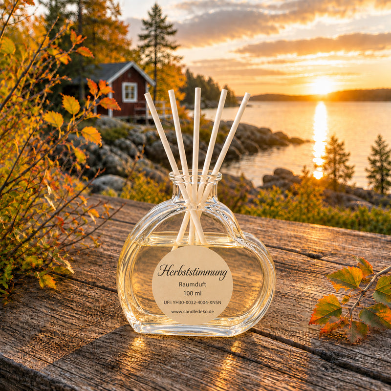 Herbststimmung Raumduft CandleDeko im Herzglas auf einem Tisch vor einem Seee mit Blick auf den See im Herbst.