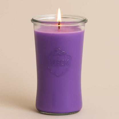 Lavendel XXL-Duftkerze im Weckglas mit brennendem Docht – klassisch lavendelfarbene Kerze auf hellem, rosé-beigem Hintergrund (#e9dfd8), 100 Stunden Brenndauer.