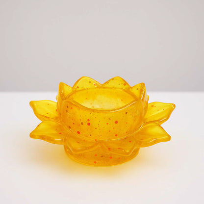 Handgefertigter Kerzenhalter in Lotosblumenform aus gelben Epoxidharz mit Glitzereffekten – auf weißem Hintergrund fotografiert.