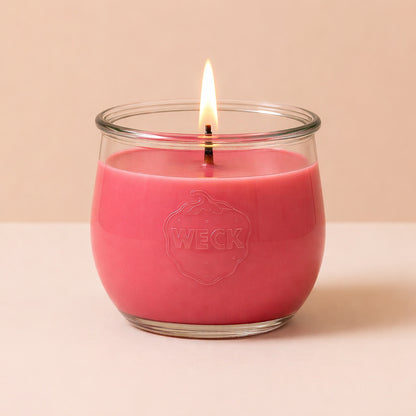 Große Duftkerze in zartem Pfingstrosenrosa – handgegossen im WECK-Glas, mit ruhiger Flamme und natürlichem Glanz, aufgenommen vor sanftem Hintergrund