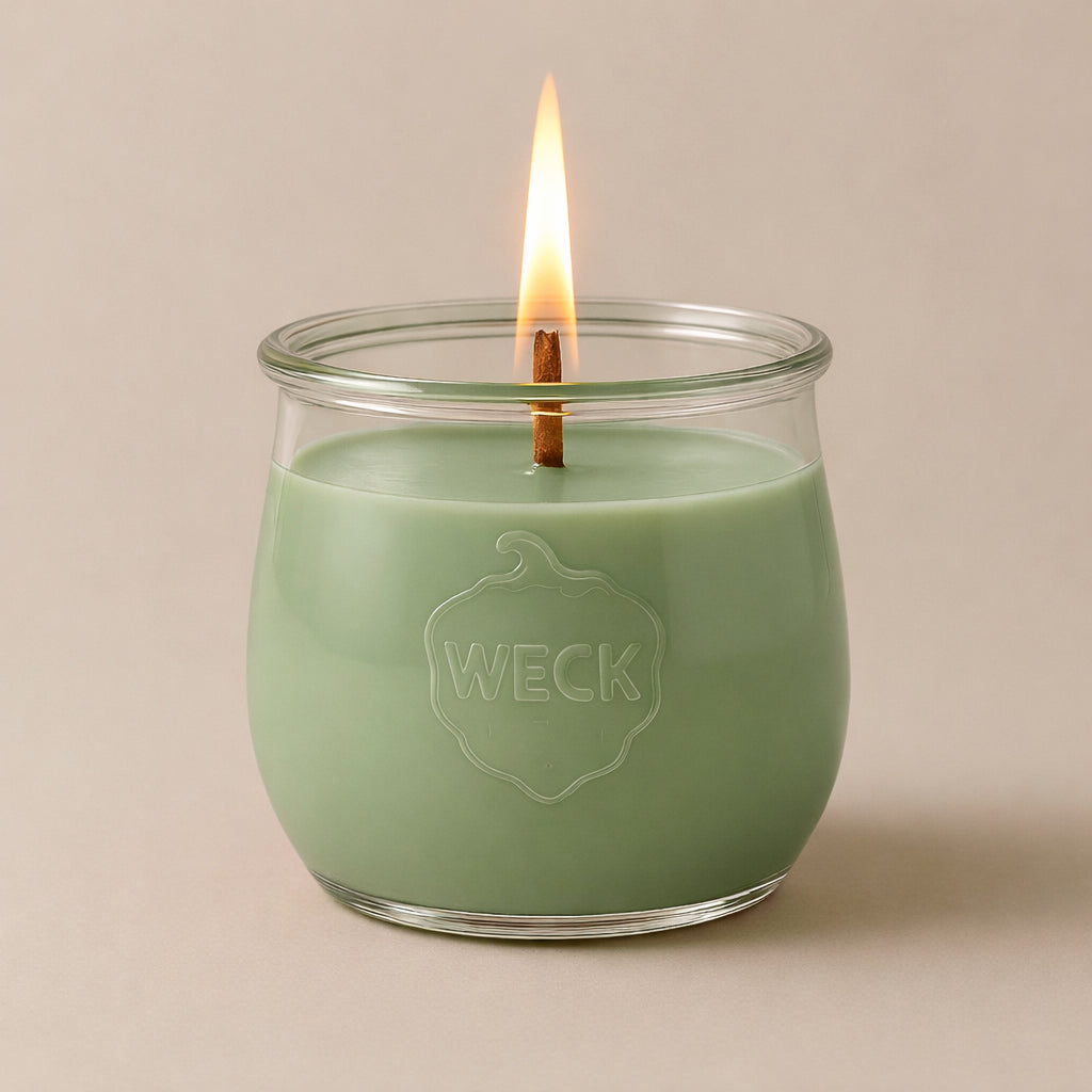 Salbeigrüne Duftkerze Teeoase im WECK-Glas mit Holzdocht, vor neutralem Hintergrund. Pflanzliches Wachs, klare Form, ruhiges Licht.