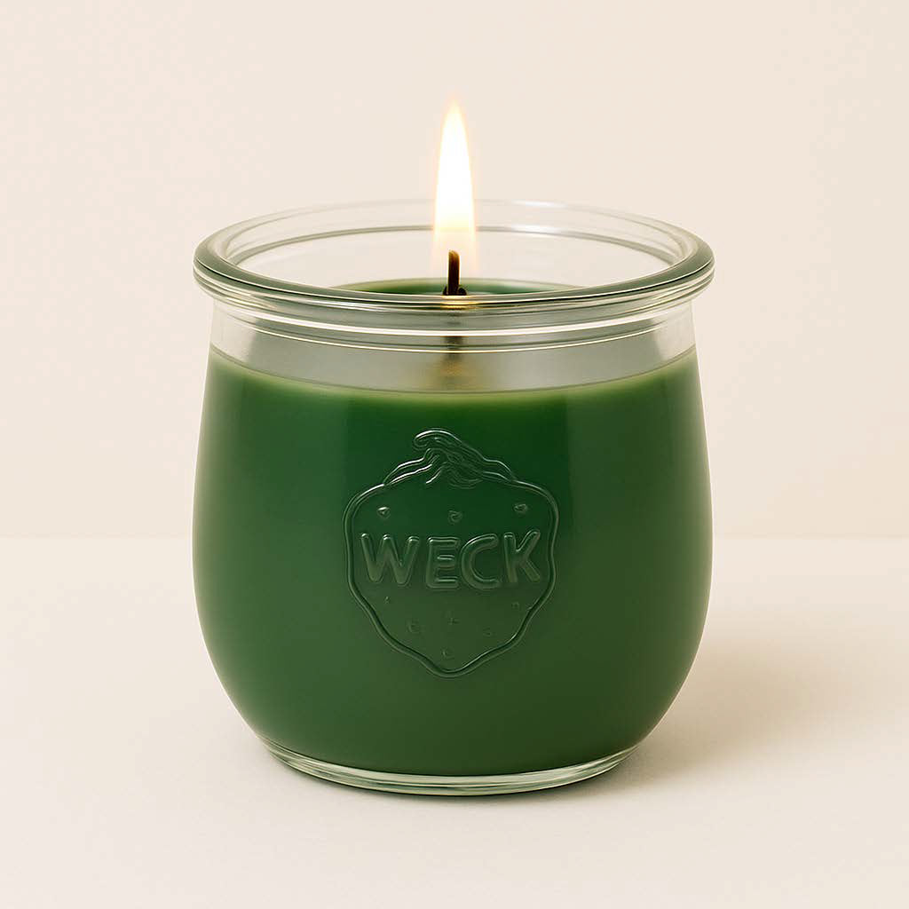 Duftkerze Waldduft im brennenden Zustand, moosgrünes Wachs im klassischen WECK-Glas, vor hellem Hintergrund