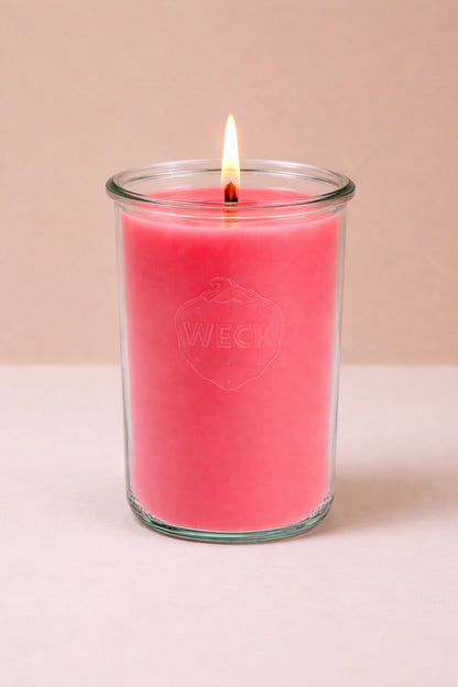 Duftkerze in hellem Rot in einem hohen WECK-Glas mit brennender Flamme, vor neutralem Hintergrund. Die Kerze symbolisiert den Duft Wassermelonensorbet in der XXL-Variante.