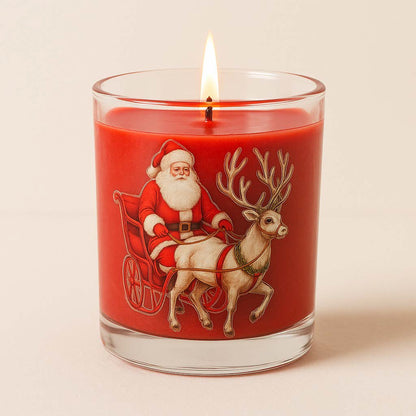 Rote Weihnachtskerze im Glas mit Santa- und Rentiermotiv, gefüllt mit 120 g Sojawachs im Duft Apfel-Zimt, vor neutralem Hintergrund.