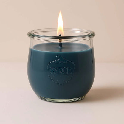 Graublaue Duftkerze Windstille im WECK-Glas, klassisches Design mit Baumwoll-Docht, brennend mit warmer Flamme vor neutralem Hintergrund