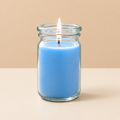 blaue kleine brennende Duftkerze von Candledeko vor neutralem Hintergrund