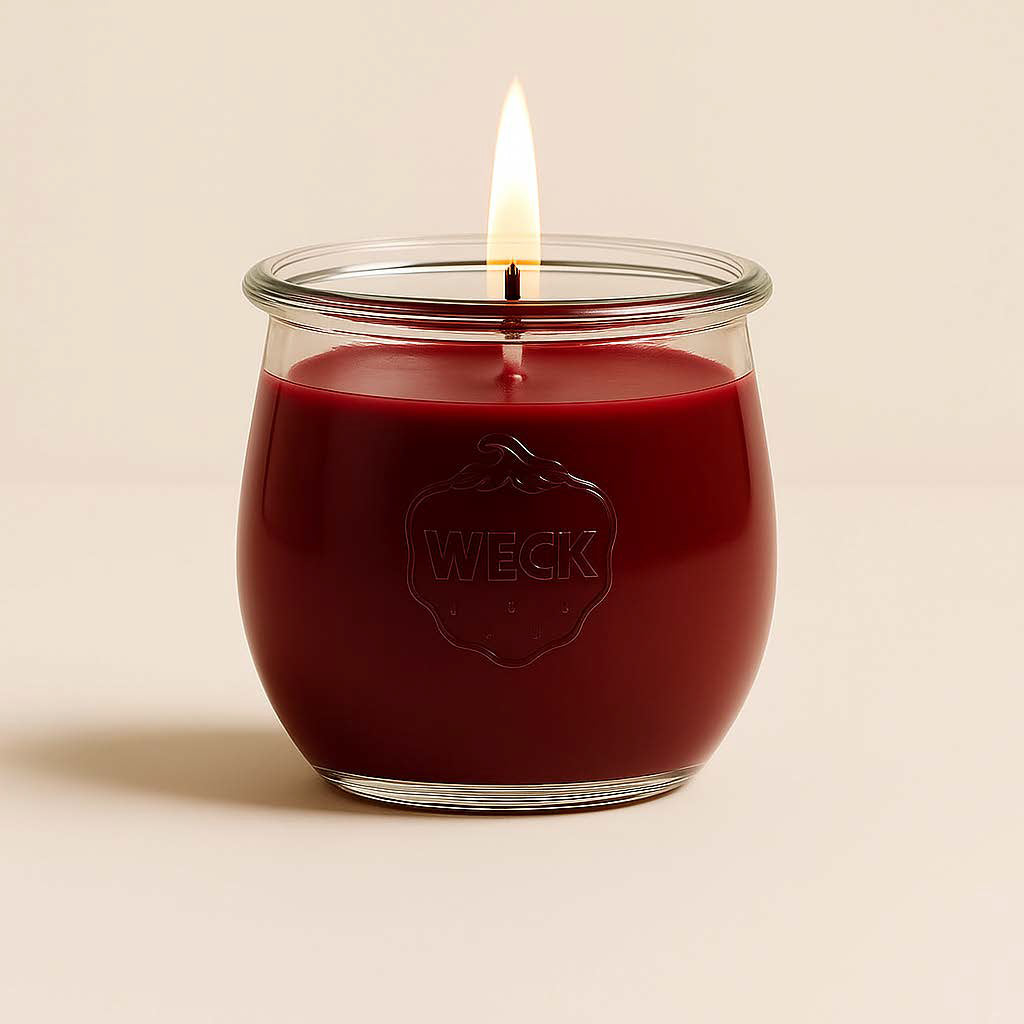 Brennende lila CandleDeko grosse Duftkerze im WECK-Tulpenglas vor neutralem Hintergrund.