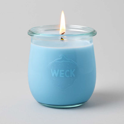 Brennende hellblaue CandleDeko große Duftkerze im originalen WECK-Glas vor einem neutralen Hintergrund.