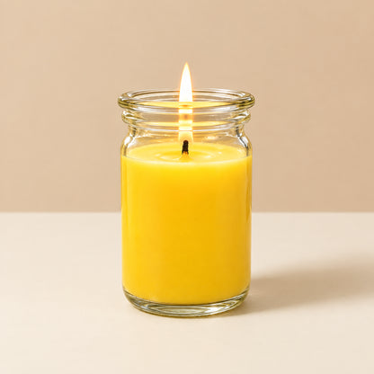 Gelbe kleine Duftkerze aus Kokoswachs im  WECK-Glas von CandleDeko, brennend vor neutralem Hintergrund.