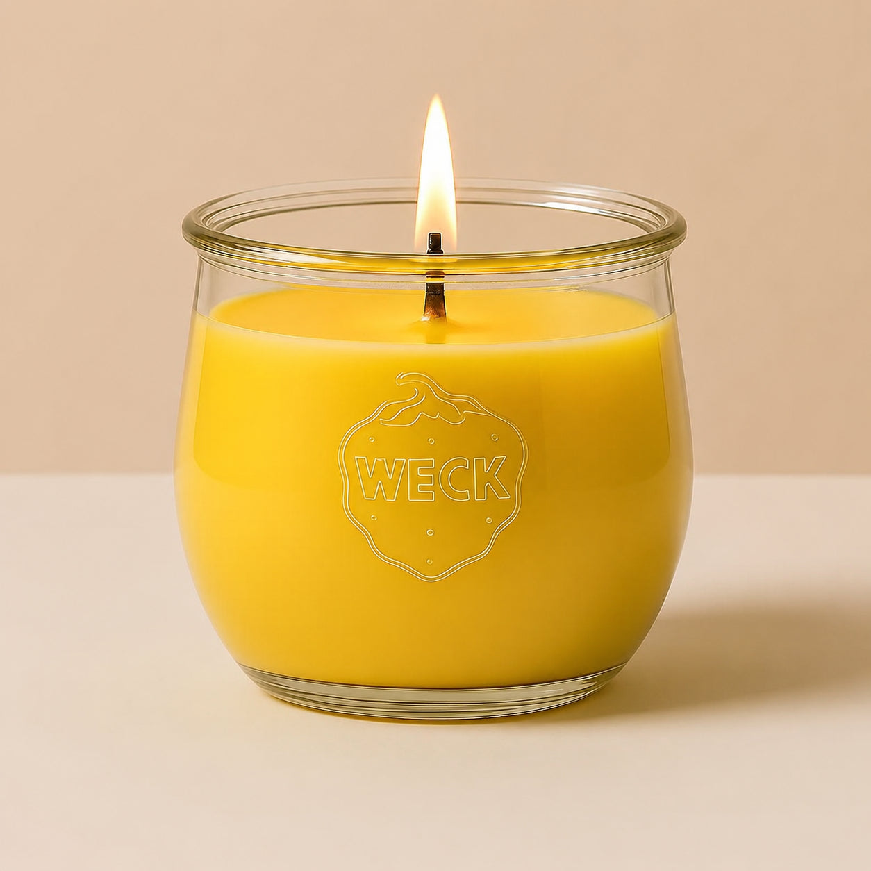 Brennende gelbe CandleDeko Grande Duftkerze im bauchigen, eleganten WECK-Glas vor neutralem Hintergrund.