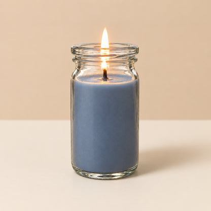 Graublaue kleinee Duftkerze aus Kokoswachs im WECK-Glas von CandleDeko, brennend vor neutralem Hintergrund.