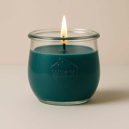 Brennende graublaue CandleDeko grosse Duftkerze im WECK-Tulpenglas vor neutralem Hintergrund.
