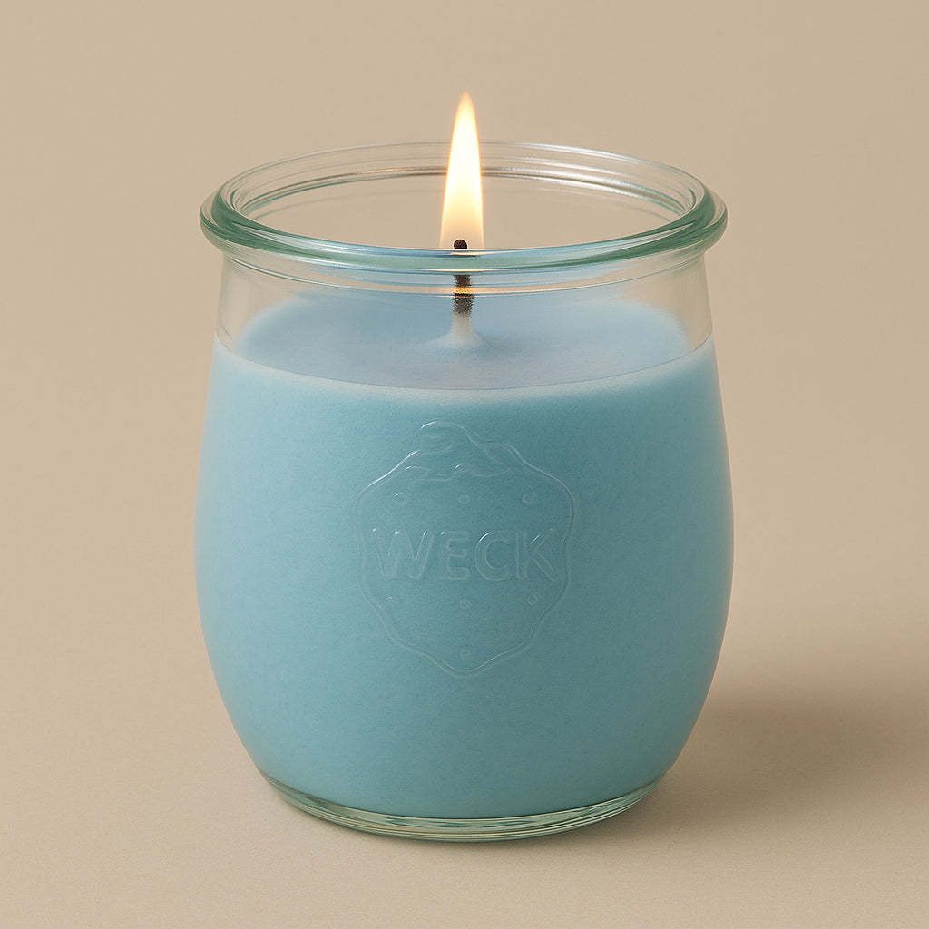 Brennende hellblaue CandleDeko große Duftkerze im originalen WECK-Glas vor einem neutralen Hintergrund.