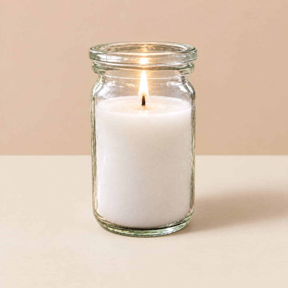 Weiße kleine Duftkerze aus Kokoswachs im WECK-Glas von CandleDeko, brennend vor neutralem Hintergrund.