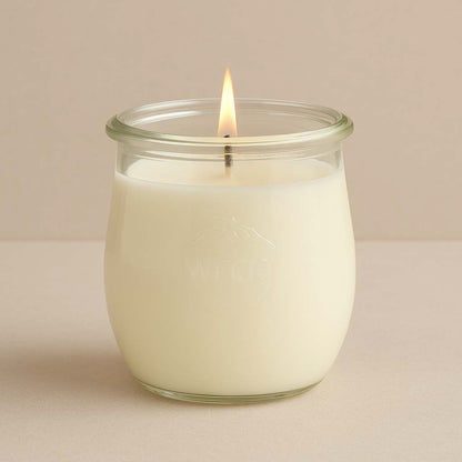 Brennende weisse CandleDeko grosse Duftkerze im WECK-Tulpenglas vor neutralem Hintergrund.