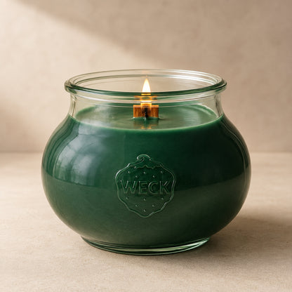 Grüne Grande Duftkerze mit 140 Std. Brenndauer aus Pflanzenwachs im bauchigen, eleganten WECK-Glas von CandleDeko, brennend vor neutralem Hintergrund.