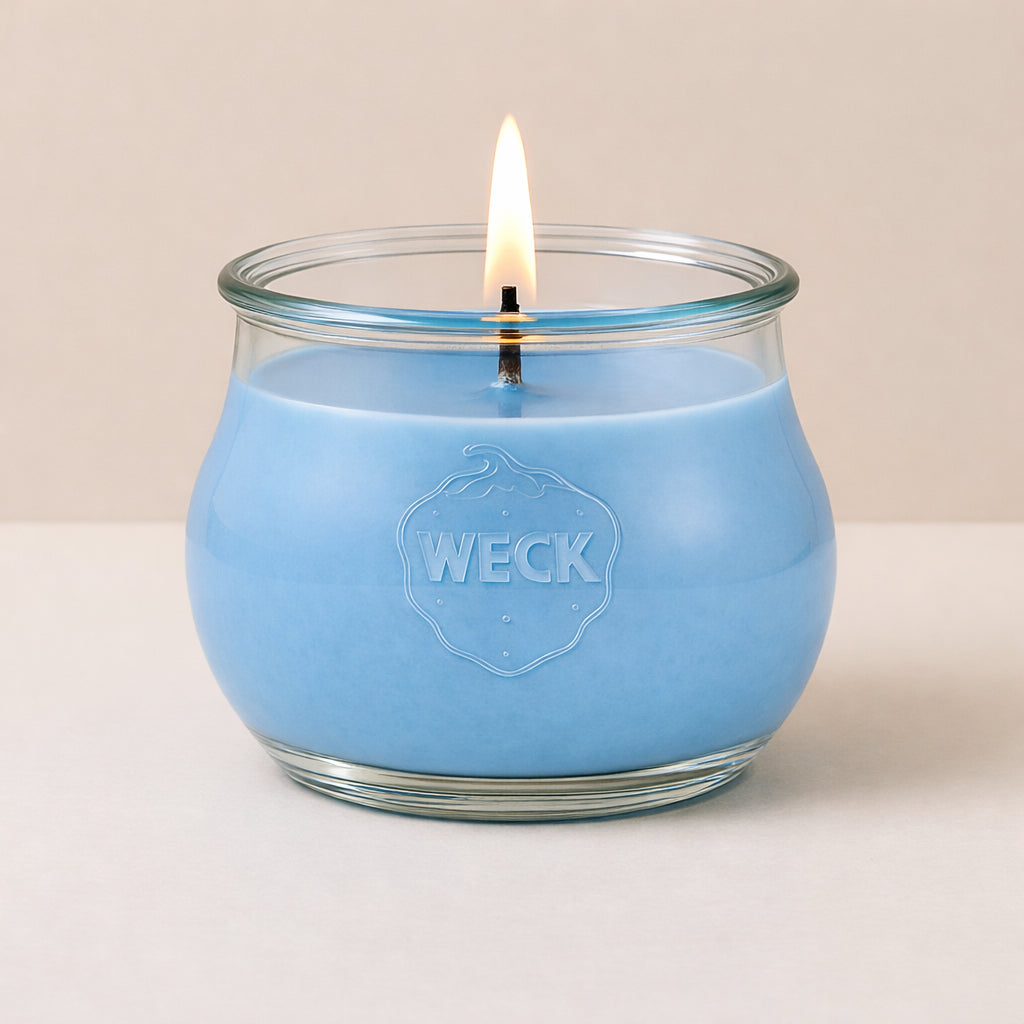 Brennende hellblaue CandleDeko große Duftkerze im originalen bauchigen WECK-Glas vor neutralem Hintergrund.