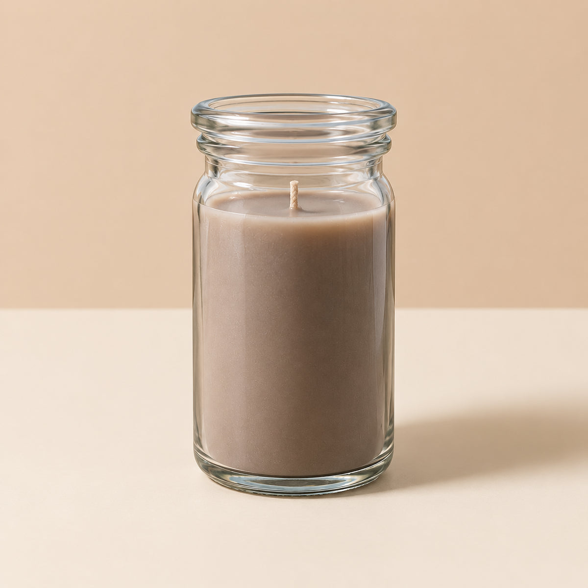 Taupefarbene kleine Duftkerze aus Kokoswachs im originalen WECK-Glas von CandleDeko, brennend vor hellem, neutralem Hintergrund.Hintergrund.