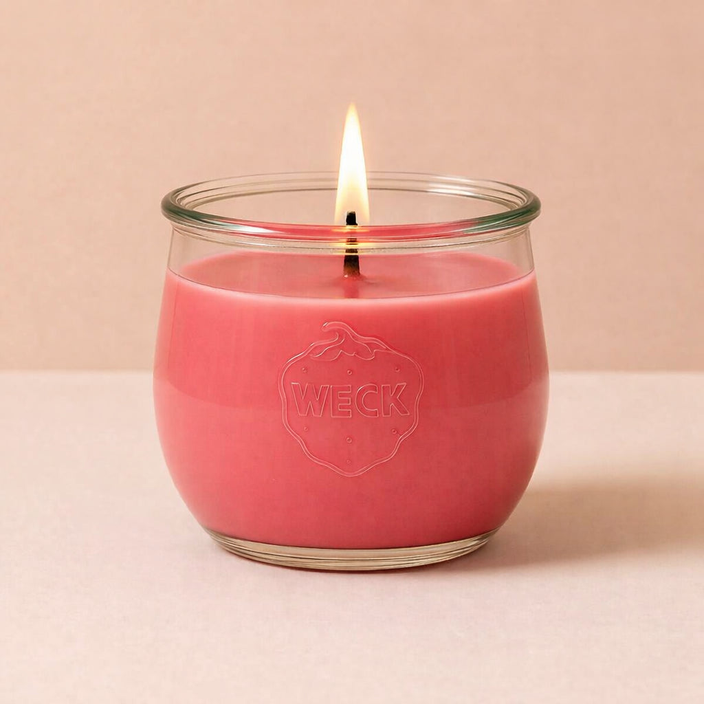 Brennende hellrote CandleDeko grosse Duftkerze im WECK-Tulpenglas vor neutralem Hintergrund.