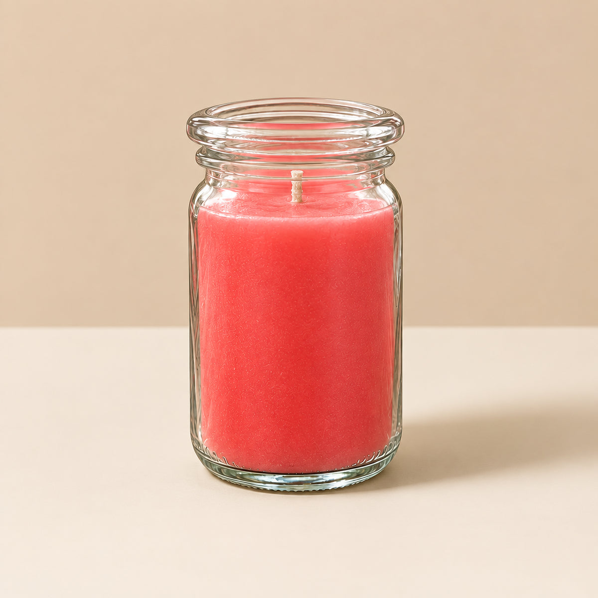 Brennende rosa CandleDeko kleine Duftkerze im WECK-Tulpenglas vor neutralem Hintergrund.