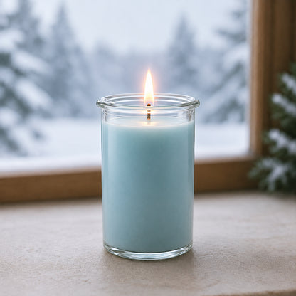 Duftkerze „Weiße Weihnachten“ aus natürlichem Kokoswachs mit intensivem Dufterlebnis im WECK-Glas, auf fensterbank vor verschneitem Wald.