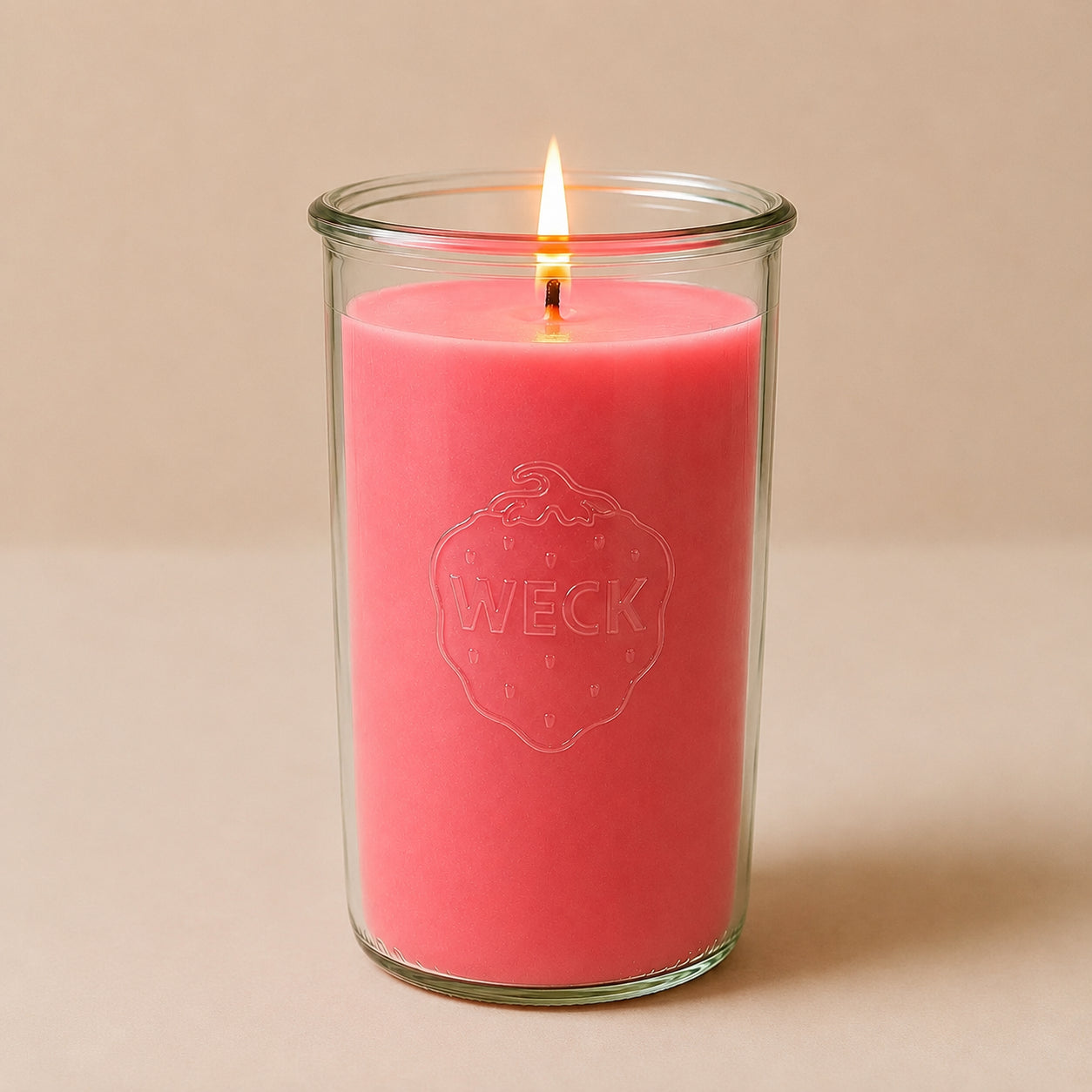 Brennende rosa CandleDeko XXL Duftkerze im hohen WECK-Sturzglas vor neutralem Hintergrund.
