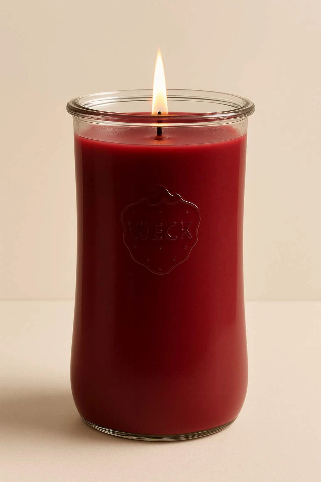 Brennende rote CandleDeko XXL Duftkerze im hohen WECK-Sturzglas vor neutralem Hintergrund.