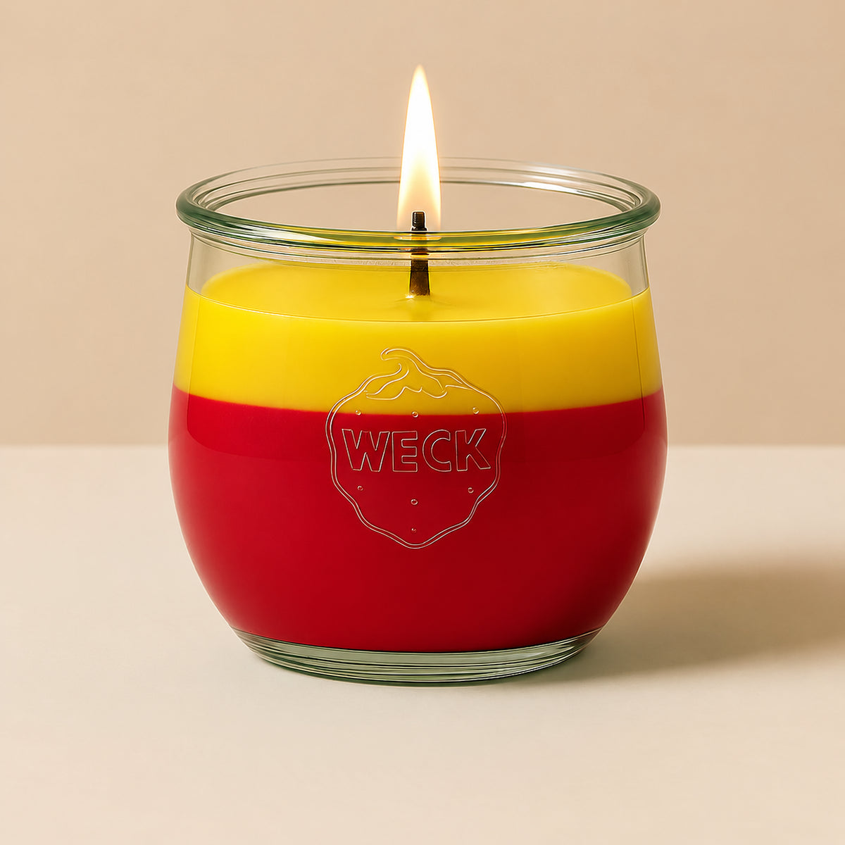 Gelb-rote große Duftkerze aus Kokoswachs im WECK-Tulpenglas von CandleDeko, vor neutralem Hintergrund.