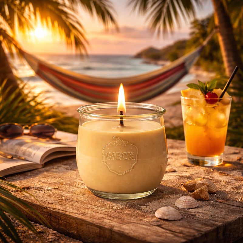 Brennende sandfarbene CandleDeko Karibikflair grosse Duftkerze im WECK-Tulpenglas am Strand im Sonnenuntergang.