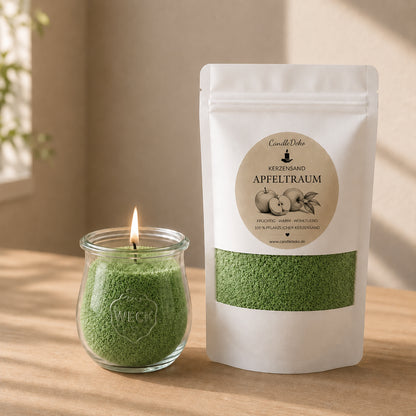 Ein weißer CandleDeko Nachfüllbeutel mit grünem Kerzensand Apfeltraum neben einer brennenden Kerze im bauchigen WECK-Glas auf einem hellen Holztisch.