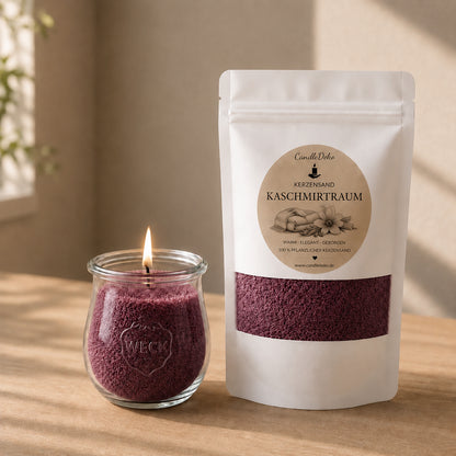 Ein weißer CandleDeko Nachfüllbeutel mit beerenrotem Kerzensand Kaschmirtraum neben einer brennenden Kerze im bauchigen WECK-Glas auf einem hellen Holztisch.