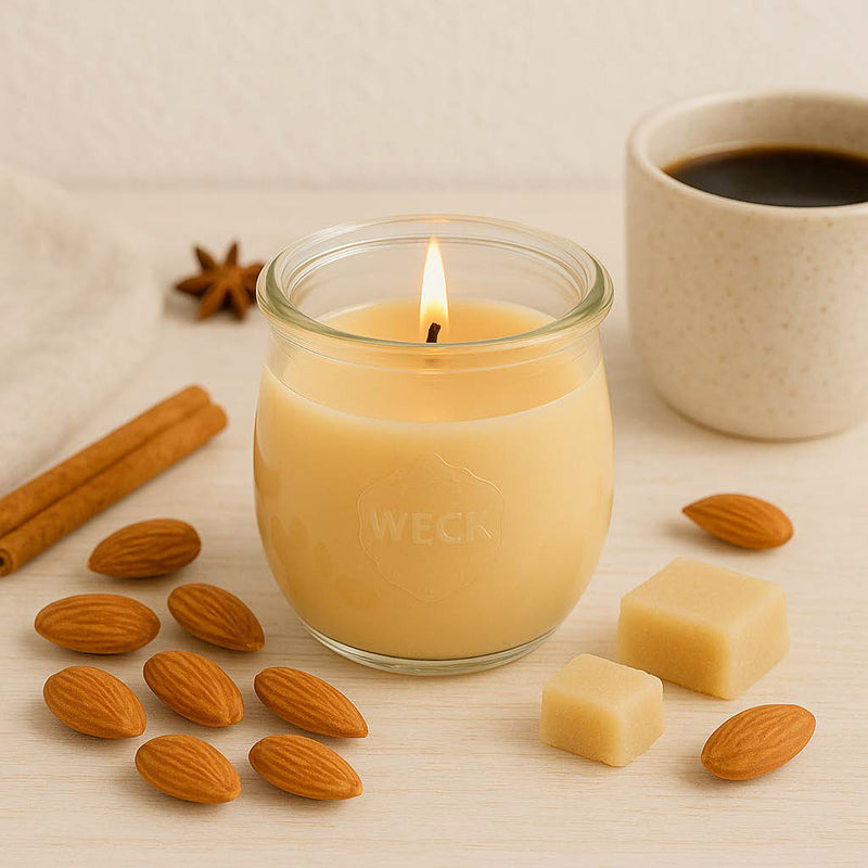 Große Marzipan und Mandel Duftkerze aus Kokoswachs im WECK-Tulpenglas neben frischem Kaffee, Marzipan und Mandeln.