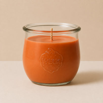Orangefarbene große Duftkerze aus Kokoswachs im WECK-Tulpenglas von CandleDeko, vor neutralem Hintergrund.
