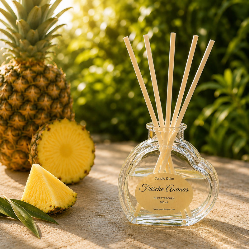 CandleDeko Ananas Raumduft im Herzglas auf einer Natursteinplatte zwischen frischer Ananas im warmen Sommerlicht