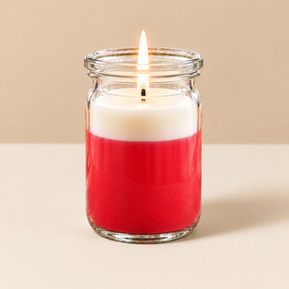 Rot-weiße kleine Duftkerze aus Kokoswachs im originalen WECK-Glas von CandleDeko, brennend vor neutralem Hintergrund.