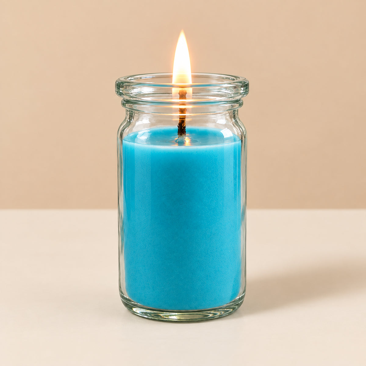 Türkise kleine Duftkerze aus Pflanzenwachs im bauchigen, eleganten WECK-Glas von CandleDeko, brennend vor neutralem Hintergrund.