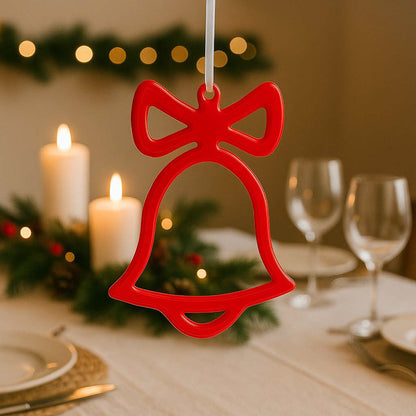 Rote handgemachte Epoxidharz-Weihnachtsglocke hängend über einem festlich gedeckten Weihnachtstisch