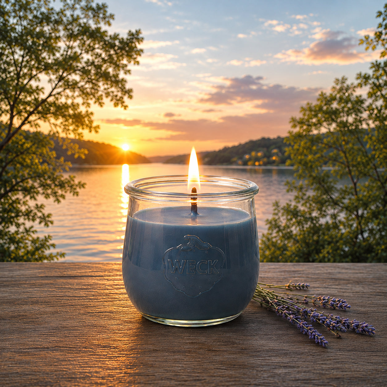 Große Windstille Duftkerze aus Kokoswachs im WECK-Tulpenglas neben Lavendel vor einem See im Sonnenuntergang.