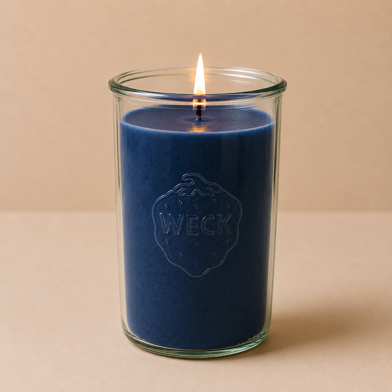 Brennende hellblaue CandleDeko XXL Duftkerze im hohen WECK-Sturzglas vor neutralem Hintergrund
