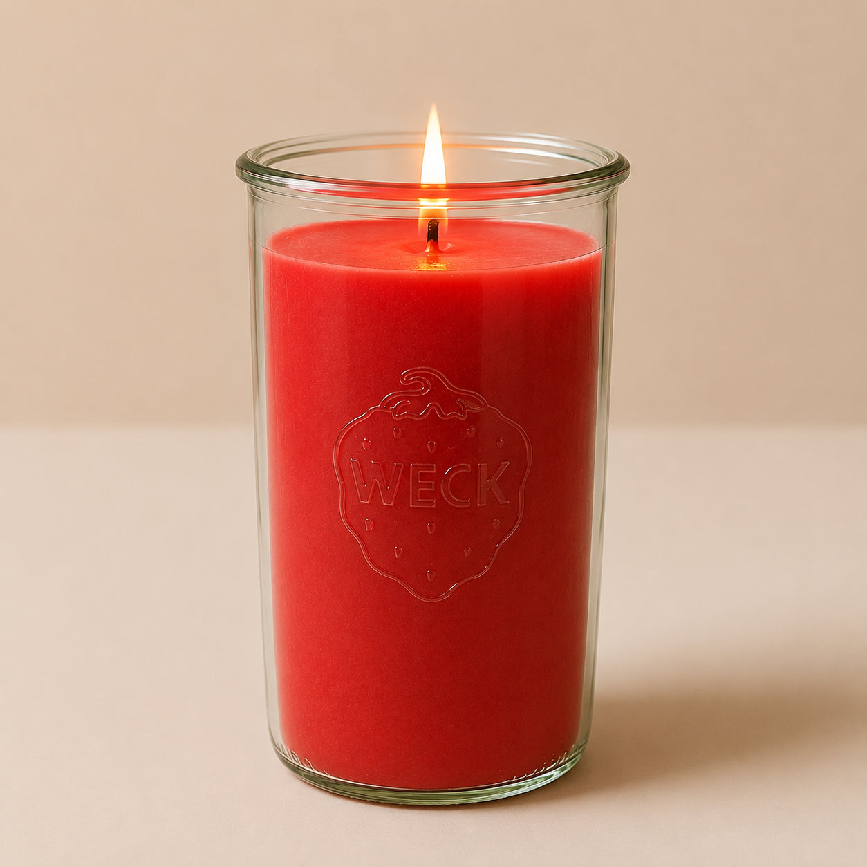 Brennende rote CandleDeko XXL Duftkerze im hohen WECK-Sturzglas vor neutralem Hintergrund.