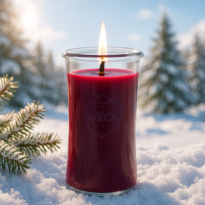 Winterbeeren XXL Duftkerze aus Kokoswachs im großen WECK-Glas von CandleDeko, dunkelrot und brennend im tiefen Schnee vor Winterwald.