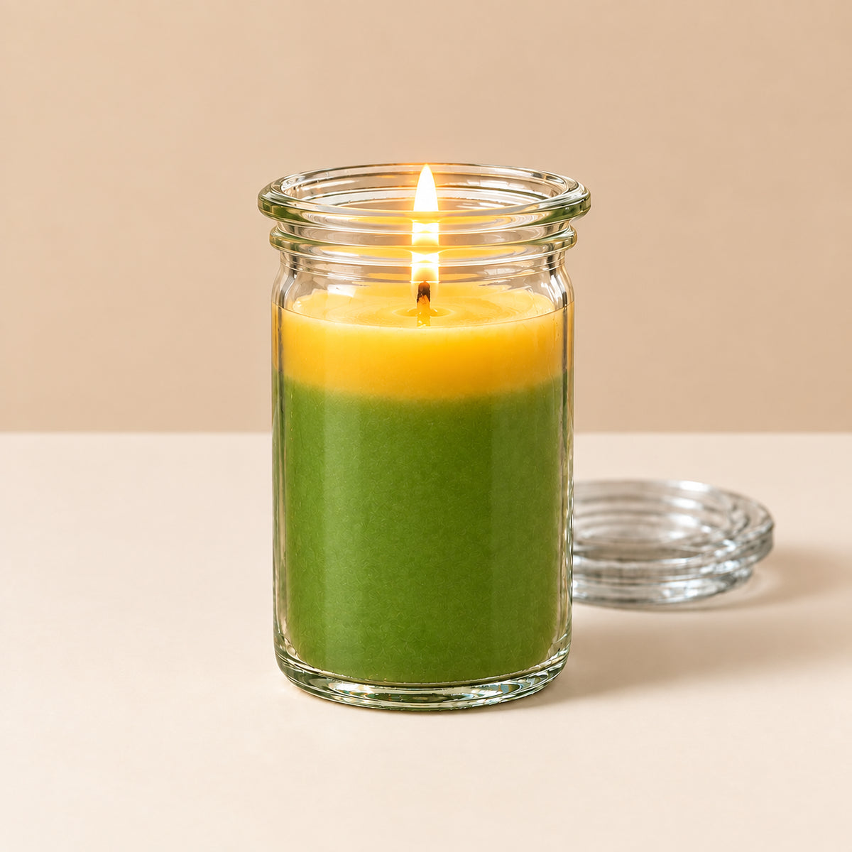 Zweifarbige kleine Duftkerze aus Kokoswachs im WECK-Tulpenglas von CandleDeko, grün-oranges Wachs vor neutralem Hintergrund.
